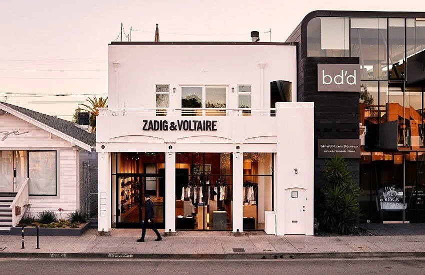Zadig & Voltaire storefront on Abbot Kinney Boulevard, Venice, with a pedestrian passing at dusk