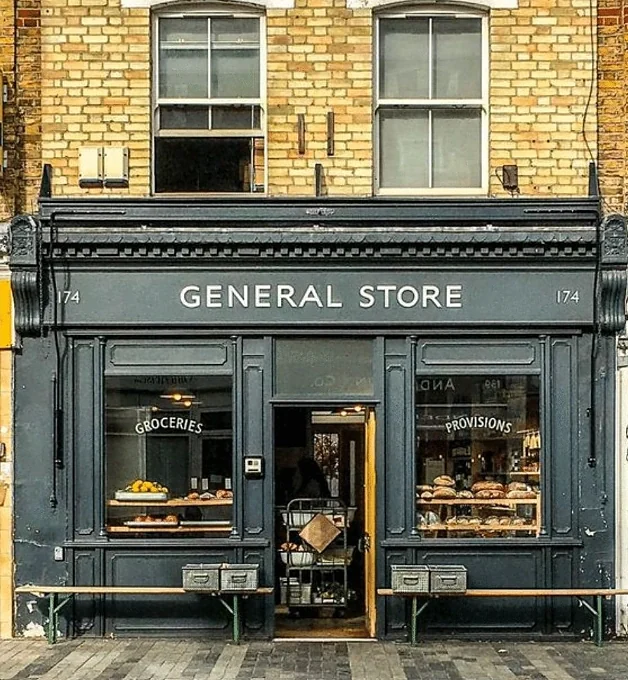 Dark-painted General Store shopfront with bread in the windows
