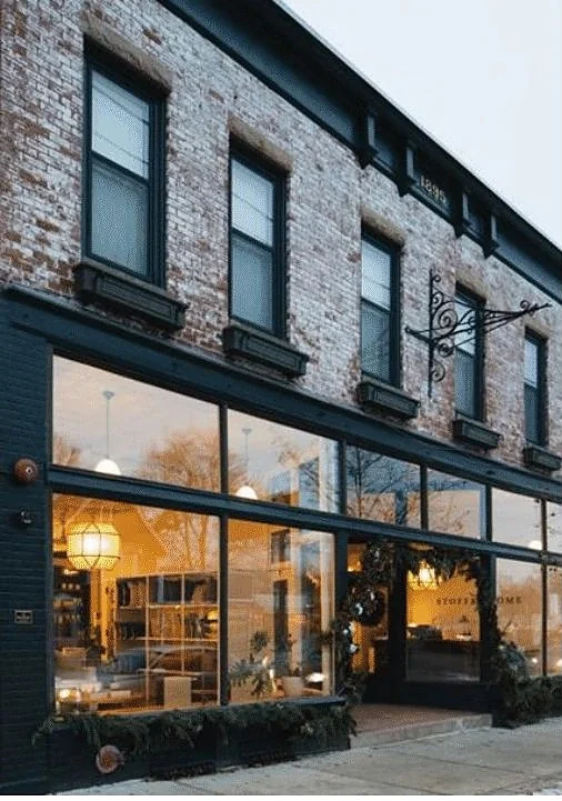 Painted brick shopfront with warm-lit interior